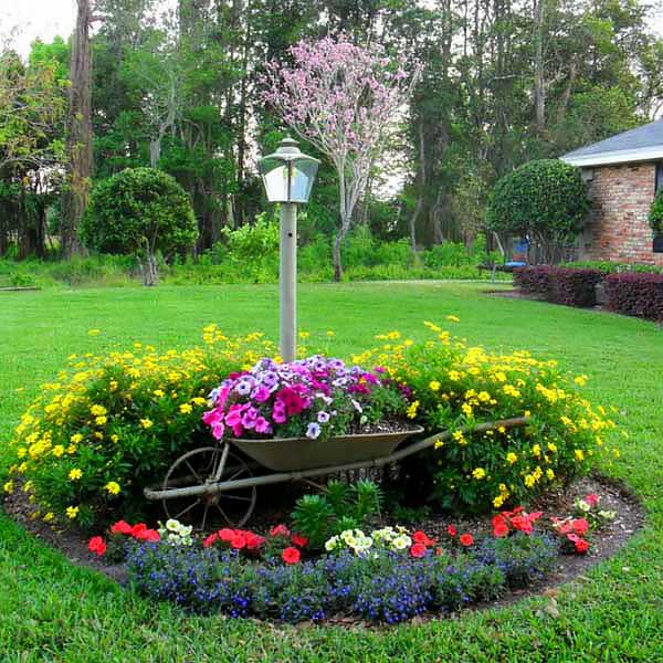 Round small flowers garden idea with recycled wheel barrow. #gardens #gardening #gardenideas #gardeningtips #landscapedesign #decorhomeideas