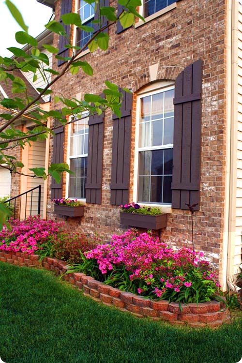 Raised brick flower bed around house