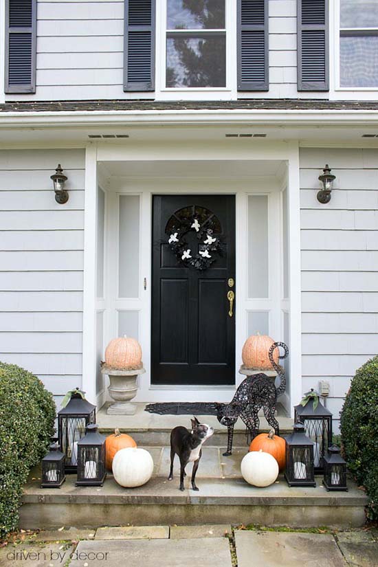 Front porch Halloween decorations with pumpkins in urns and cats #halloweendecorations #halloween #diyhalloween #halloweendecor #decorhomeideas