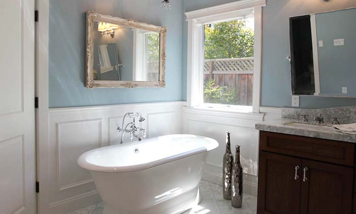 Clawfoot bathtub with wainscoting bathroom wall in light blue