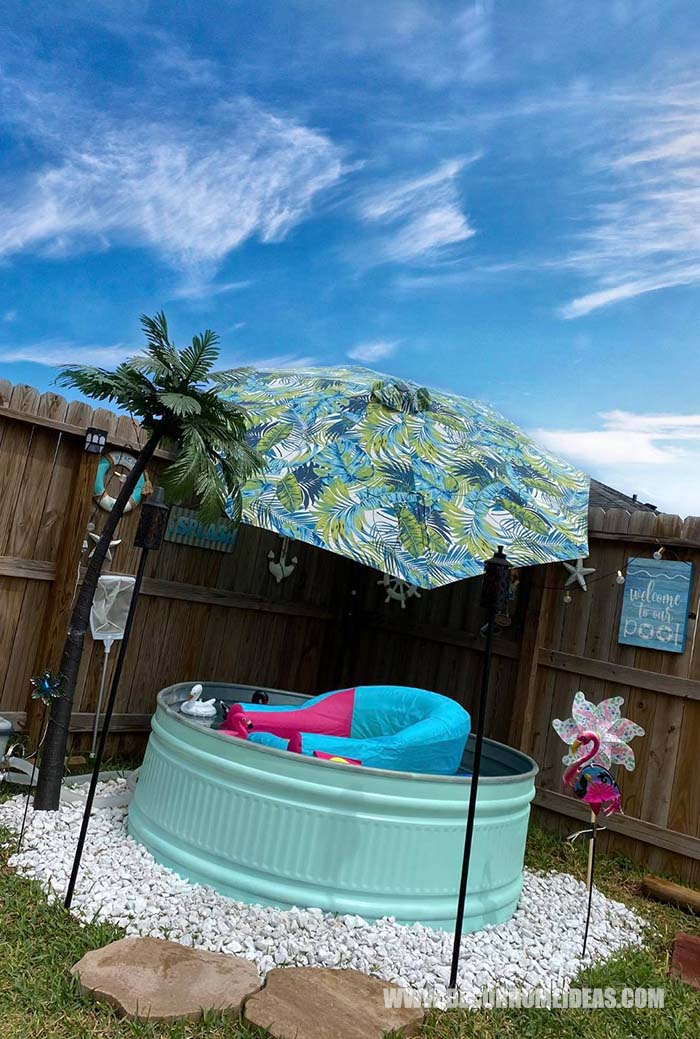 DIY Stock Tank Pool With Fake Palm And Umbrella