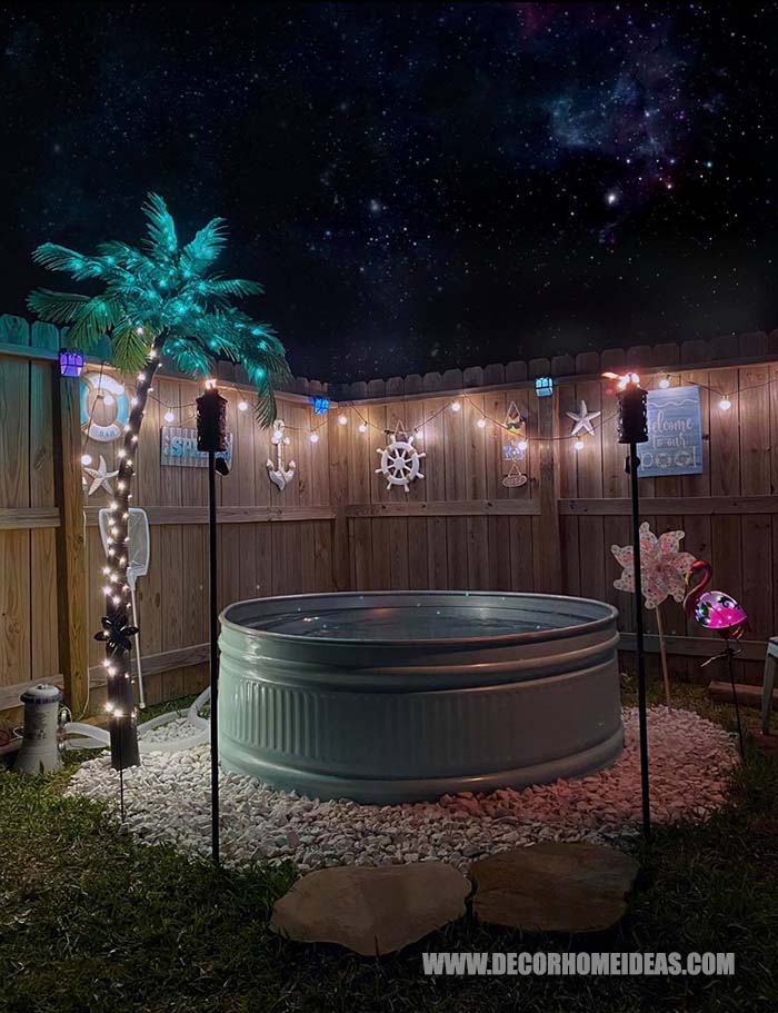 How To DIY Stock Tank Pool Idea. How it looks at night with fake palm tree and string lights around it. #stocktankpool #pool #decorhomeideas