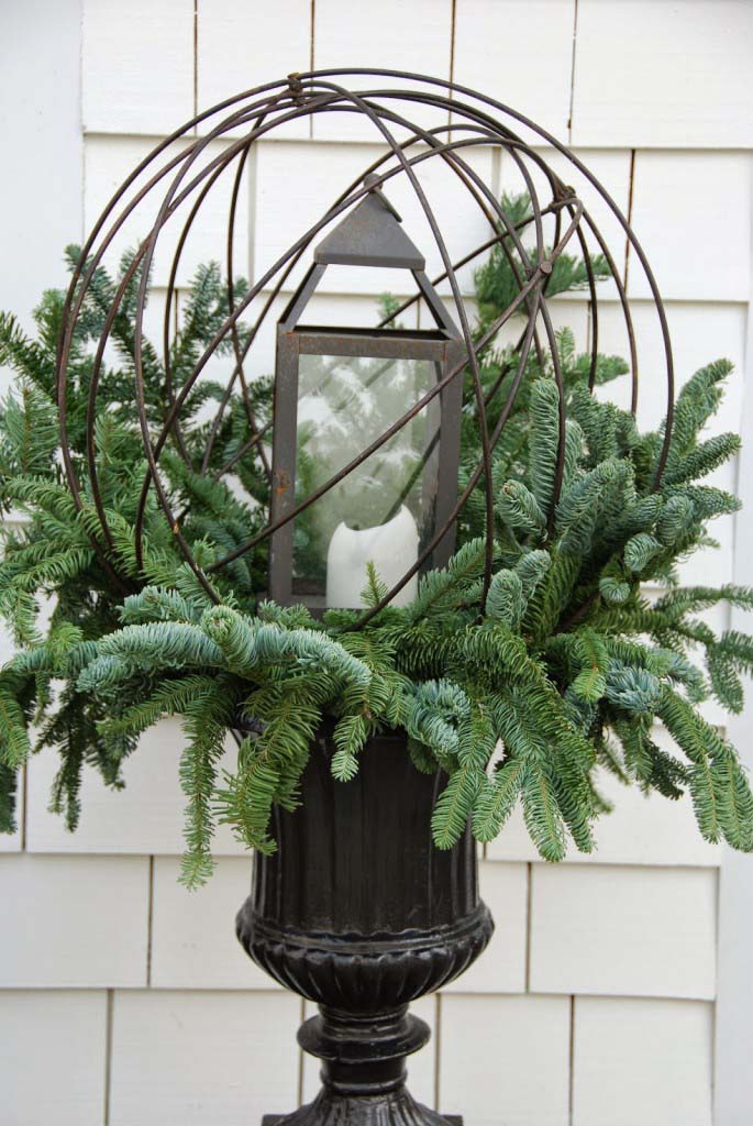Cage Lantern in a Pine-Stuffed Urn #Christmas #urns #decorations #decorhomeideas