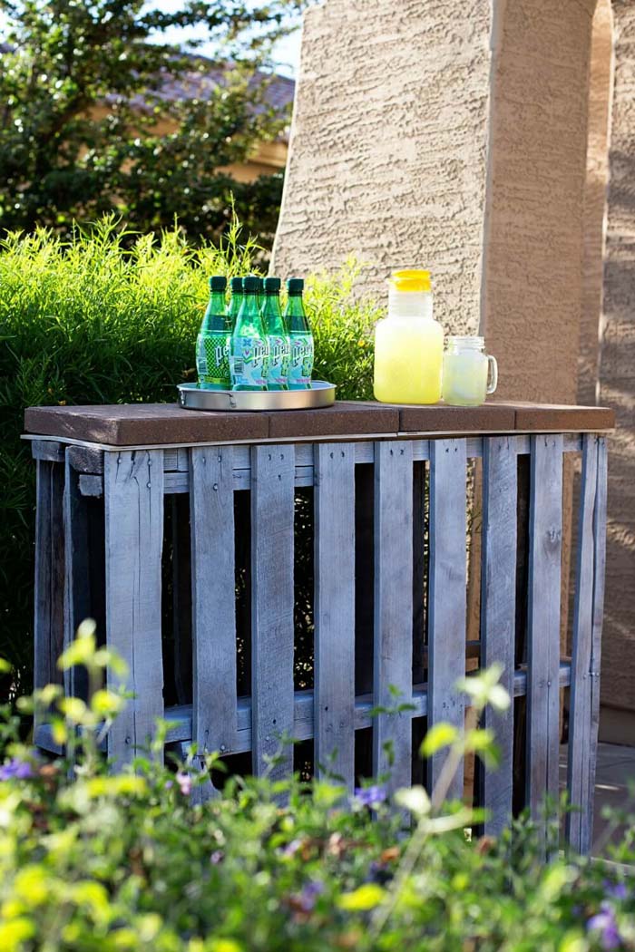 A Recycled Pallet Bar Near a Hedge #outdoorbar #diyoutdoorbar #decorhomeideas