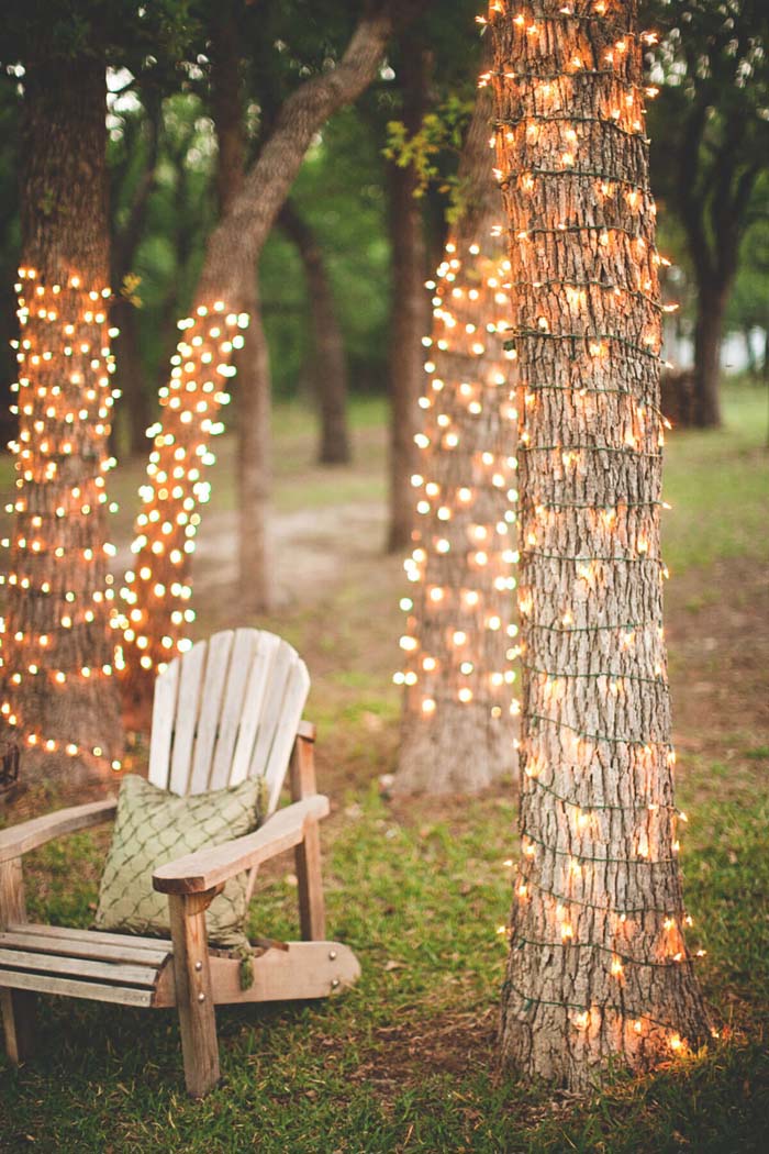 Tree Trunks Wrapped in String Lights #backyardlightingideas #decorhomeideas