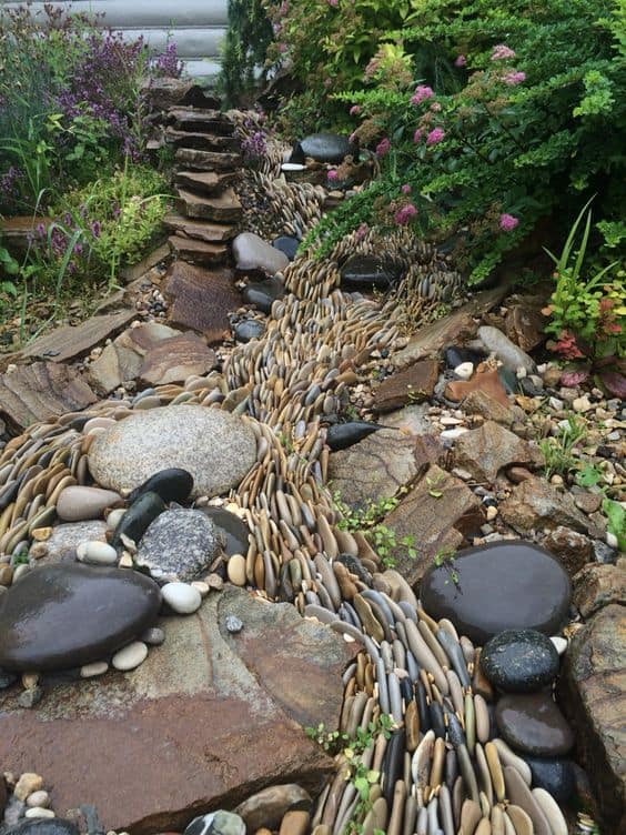 Create the Look of Running Water With River Rocks #dryriverbed #drycreek #decorhomeideas