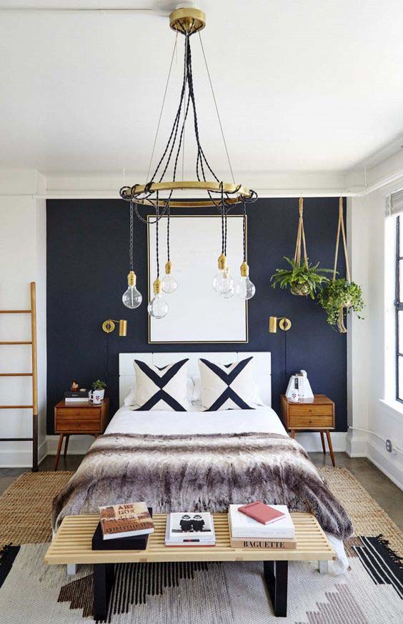 A Boho Chic Bedroom With A Modern Navy Blue Wall And Golden Accents