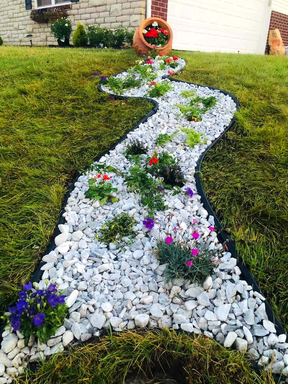 spilled terracotta pot with white rocks and small flowers