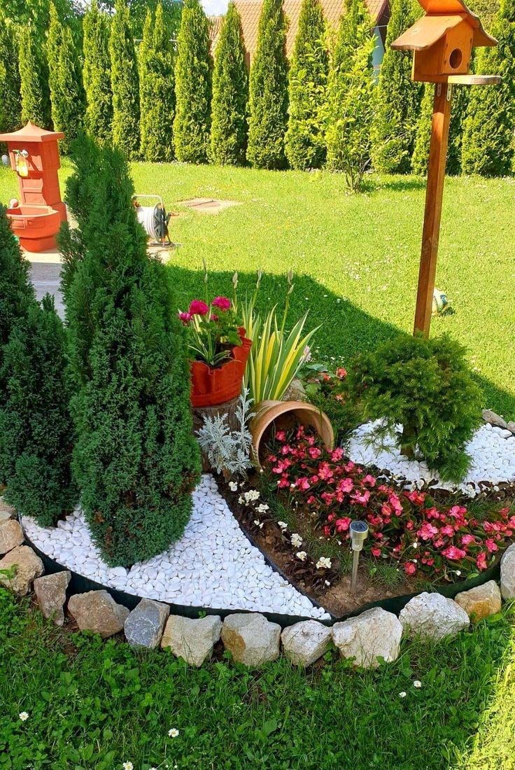 Pequeno jardim com bordas flexíveis, seixos e diferentes variedades de tábuas