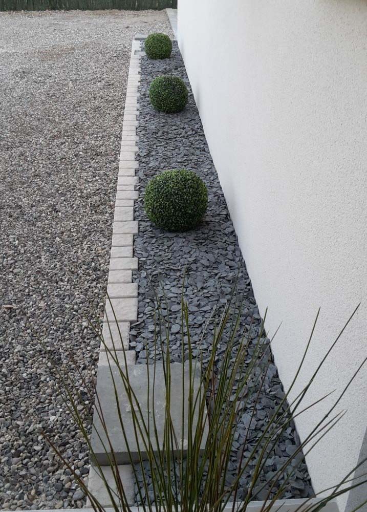 Jardín de borde con guijarros grises y adoquines de piedra