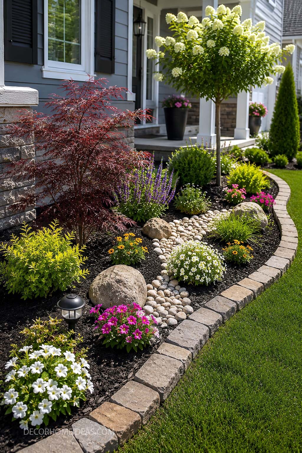 Colorful Front Yard Garden Bed with Black Mulch and Stone Edging